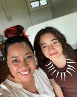 Two people taking a selfie in a bedroom.