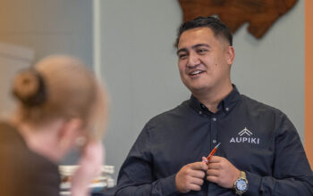 A close up of a person wearing a black shirt. On the right is a graphic representing the values of Ringa Hora.