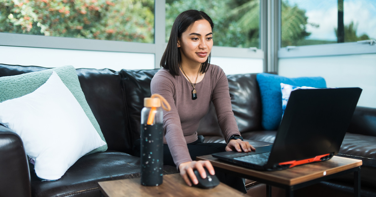 Young Maori woman working from home using laptop in Auckland, New Zealand.